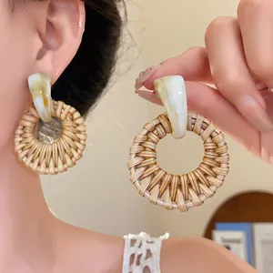Nahaufnahme von geflochtenen Boho-Ohrringen aus Rattan mit Marmor-Effekt für den Strand.