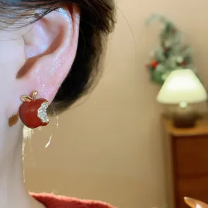 Primo piano dettagliato di un orecchino a mela rossa con brillanti zirconi pavé incastonati