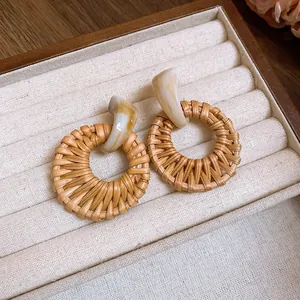 Detailansicht der runden böhmischen Rattanhänger-Ohrringe mit cremefarbenen Harzsteckern.