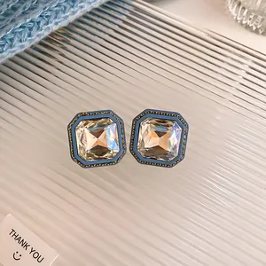 Detailed view of retro square crystal stud earrings with blue borders and gold accents.