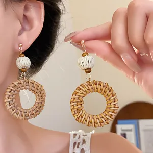 Detailansicht handgefertigter Boho-Ohrringe aus Rattan-Geflecht mit Naturholzperlen