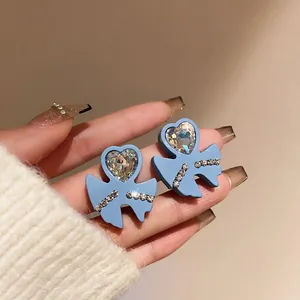 Macro detail of vintage blue matte heart earrings featuring sparkling heart rhinestones