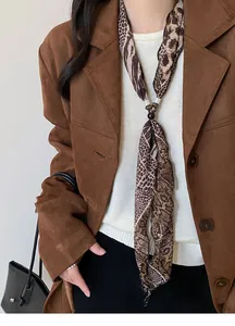 Dettaglio della collana a foulard in chiffon con stampa leopardata e pitonata su modella.