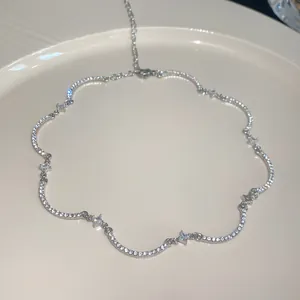 Primer plano de un collar ondulado plateado con brillantes piedras de circonita cúbica.