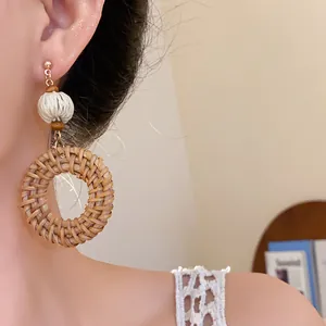 Detailansicht von Bohemian-Ohrringen mit Rattankreisen und weißen geflochtenen Perlen.