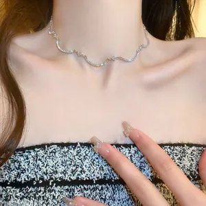 Detalle de un collar de circón brillante con diseño curvo en el cuello de una mujer