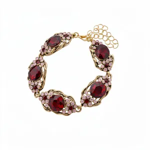 Bracelet vintage orné de cristaux rouges et finition dorée avec chaîne ajustable.