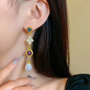 Detail of vintage palace style long earring with blue and purple stones and pearls