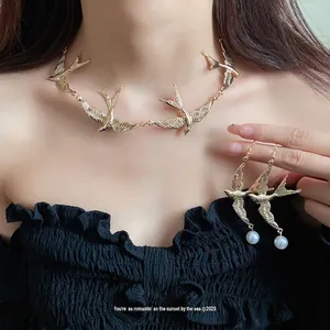 Elegante set di collana con rondine dorata e orecchini di perle coordinati da donna