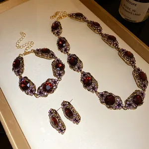 Vue détaillée d'une parure de bijoux vintage avec des pierres rouge foncé et des cristaux