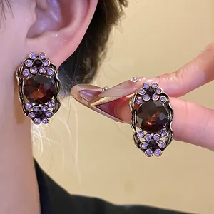Vue détaillée de boucles d'oreilles vintage en bronze avec cristaux marron et violets