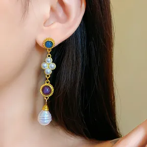 Detail shot of vintage gold earrings with purple stones and white artificial pearls