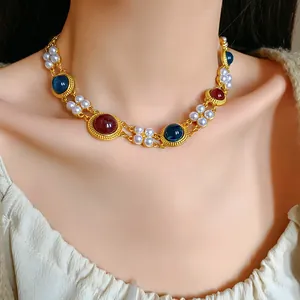Elegant vintage gold necklace with faux pearls and colored gemstones worn on model.