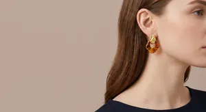 Elegant Maillard amber-style geometric hoop earrings with gold-plated finish on model's ear