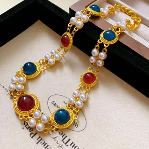 Detail view of vintage style gold-toned necklace with faux pearls and colorful gems