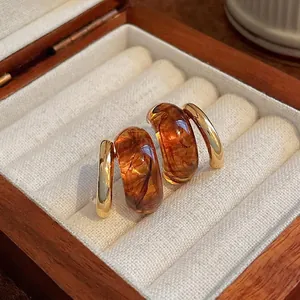 Retro geometric gold-plated silver needle earrings with amber resin in a jewelry box
