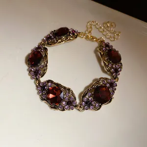 Vue détaillée d'un bracelet vintage doré avec des strass rouges et violets élégants
