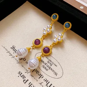 Close-up of vintage palace style gold earrings with faux pearls and colored stones