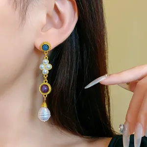 Detail view of a vintage palace style earring with colorful stones and pearls