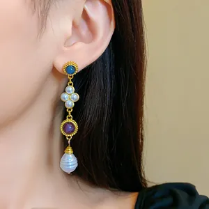 Close-up of elegant vintage palace style dangling earring with colorful stones and pearls