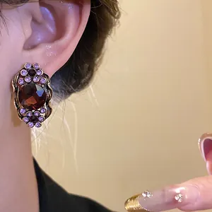 Gros plan d'une boucle d'oreille vintage en bronze avec ambre et cristaux violets