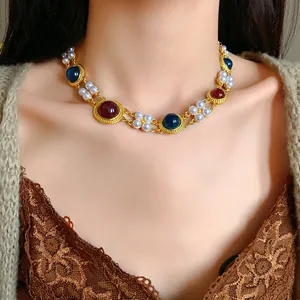 Detailed view of vintage palace style gold-tone necklace with pearls and colored gems