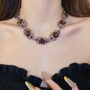 Détail d'un magnifique collier choker vintage doré avec gemmes ambre et strass violets.