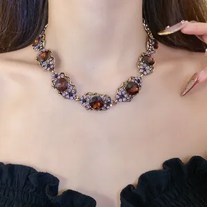 Gros plan d'un collier vintage en or avec gemmes brunes et diamants mauves