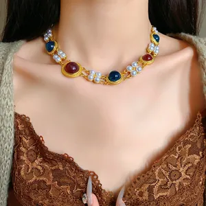 Close-up of a vintage palace style necklace with artificial pearls and colorful gems on a model