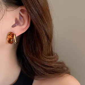 Close-up of vintage Maillard geometric gold-plated earrings on ear