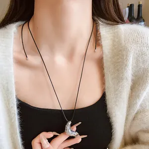 Detailansicht der silbernen Croissant-Halskette mit verstellbarem schwarzen Lederband