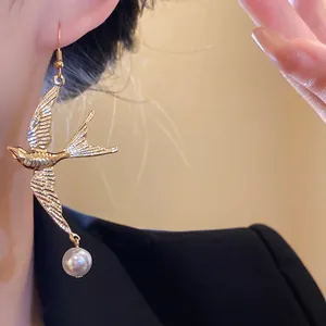 Orecchini a forma di rondine in metallo dorato con perla per un look retrò elegante