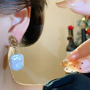 Dettaglio di un orecchino a moneta vintage placcato oro 18k con una perla barocca bianca