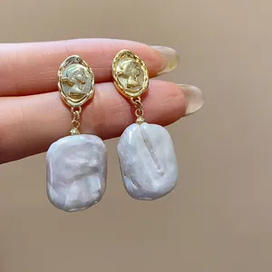 Dettaglio di orecchini di perle barocche placcati oro 18k con elegante rilievo