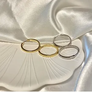 Elegante set di orecchini a cerchio minimalisti in oro e argento su un vassoio a conchiglia