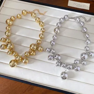 Irregular beaded choker necklace in gold and silver finish with metallic spheres.