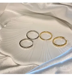 Vista dettagliata di orecchini a cerchio minimalisti in argento e oro su piatto