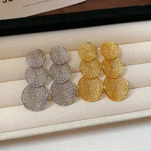 Detaillierte Makroansicht gold- und silberfarbener Mesh-Ohrringe mit drei Kreisen