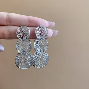 Detailaufnahme der gestuften, hohl gearbeiteten runden Filigran-Ohrhänger in Silber.