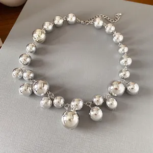 Macro detail view of a chunky silver ball necklace featuring irregular sized beads.