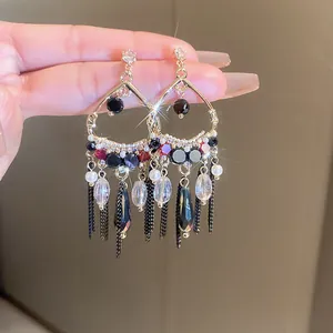 Detailed close-up of vintage style long fringe earrings with sparkling crystals and black beads