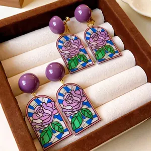 Boucles d'oreilles pendantes rose violette rétro avec motif de vitrail dans une boîte à bijoux