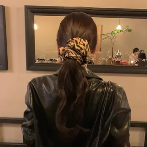 Rear view of a stylish leopard print hair scrunchie on a low ponytail hair style.