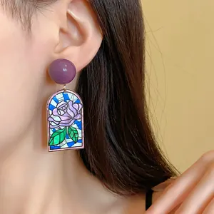 Gros plan de boucles d'oreilles rose vintage en vitrail avec perles de résine violettes