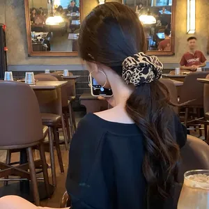 Stylish leopard print hair scrunchie shown in a low ponytail hairstyles for women