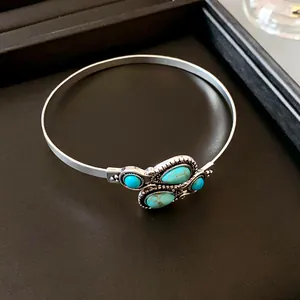 Detail of vintage silver open bangle with turquoise stone inlay for retro style jewelry