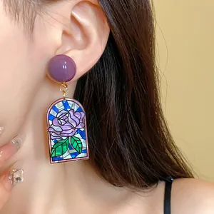 Vue détaillée d'une boucle d'oreille rose en vitrail vintage avec clou violet sur modèle