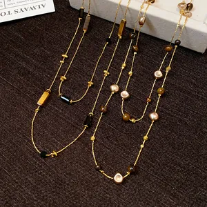 Close-up detail of retro irregular geometric beaded necklace with gold chain and stone beads