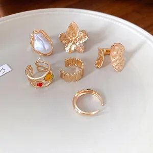 Exquisito juego de seis anillos abiertos dorados con motivos florales y perlas