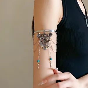 Close-up view of a bohemian silver armlet featuring delicate tassel chains and turquoise beads